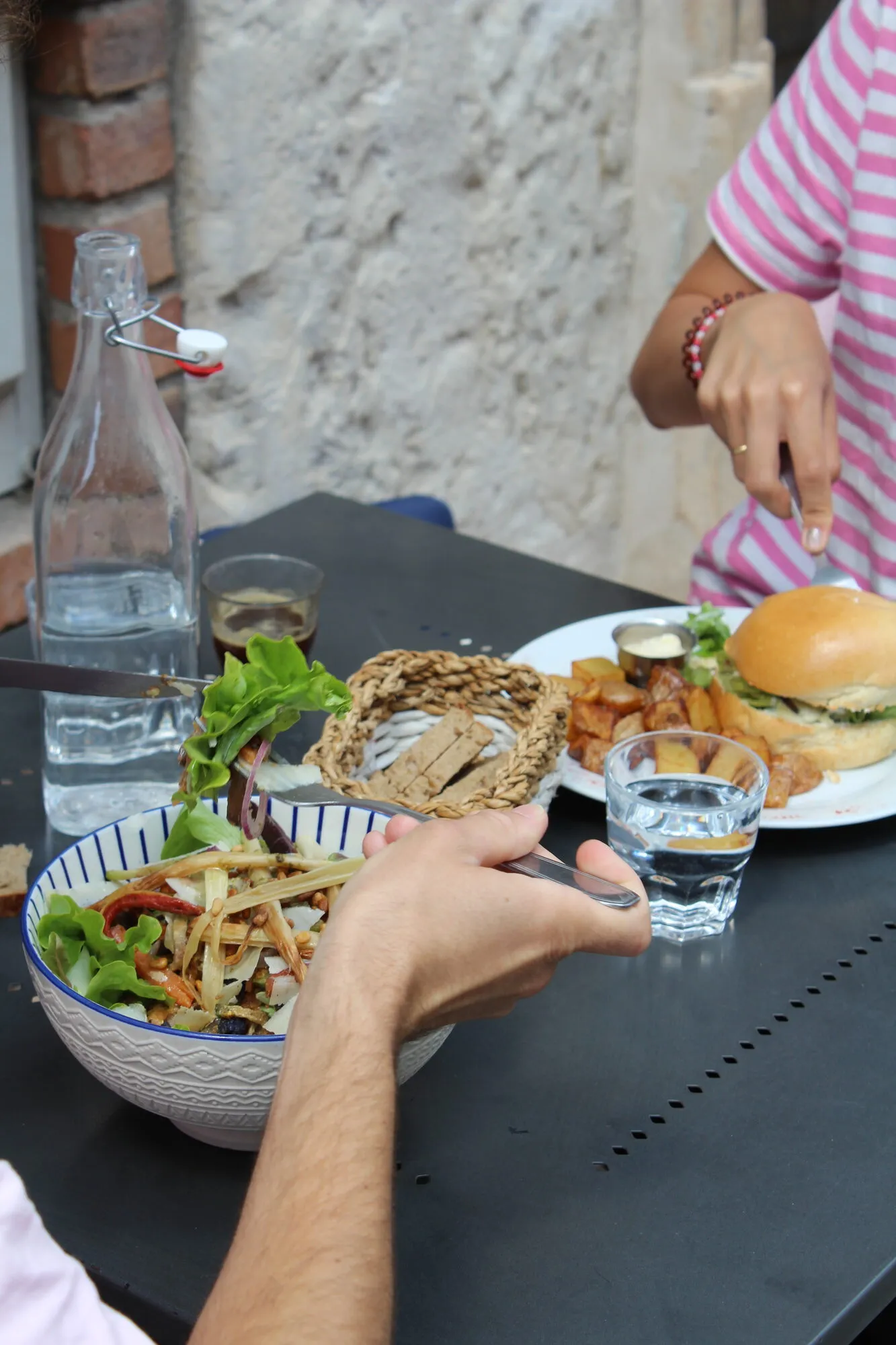 Salade et burger servis sur la terrasse