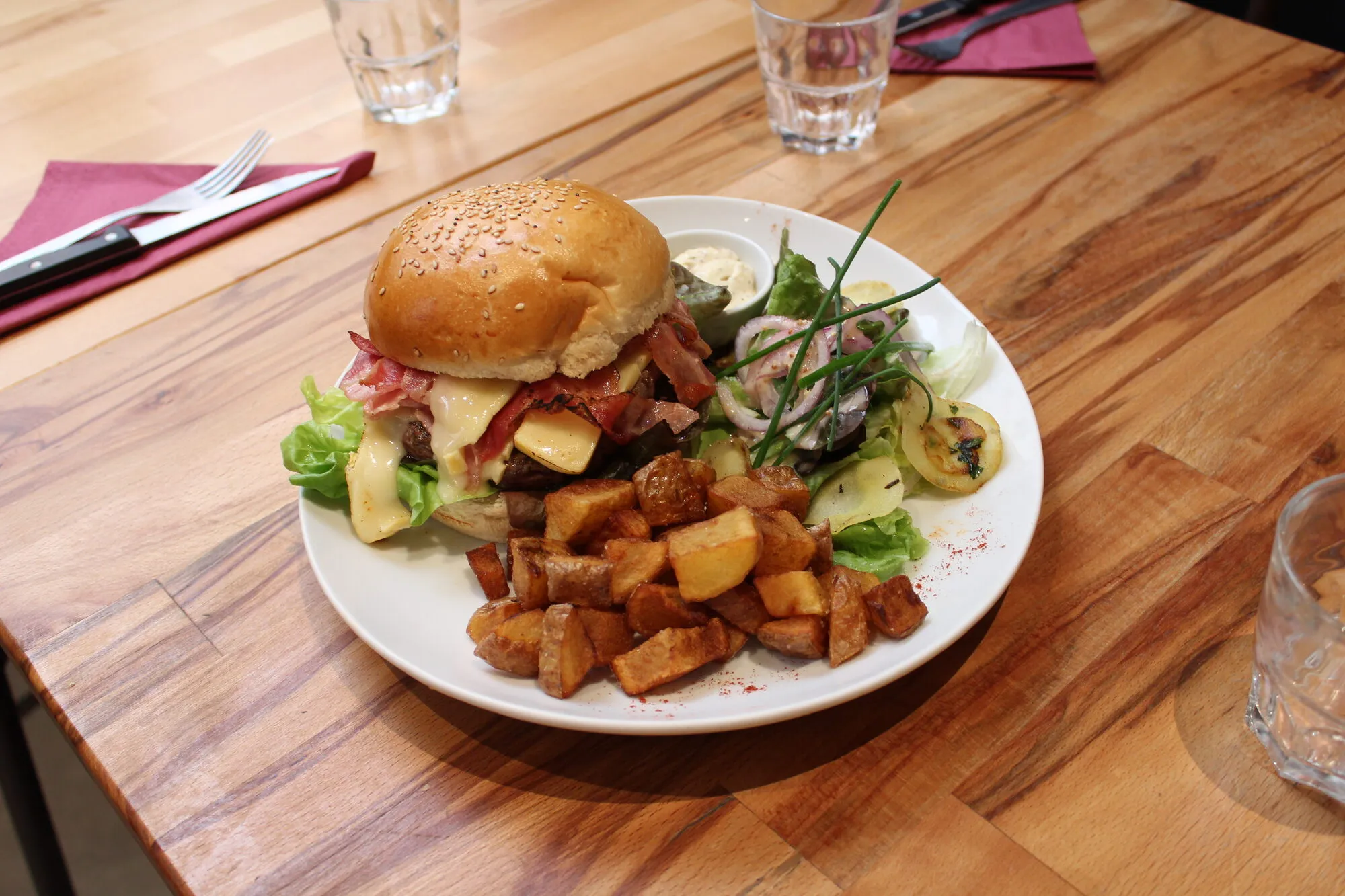 Un burger maison servi avec ses pommes de terre à La Pharmacie
